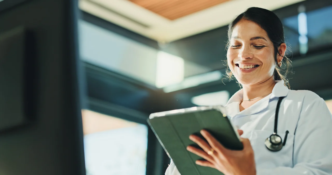 COFOMO – Specialized firm in digital transformation and artificial intelligence for the healthcare industry – Young woman using an iPad to track her team’s performance.