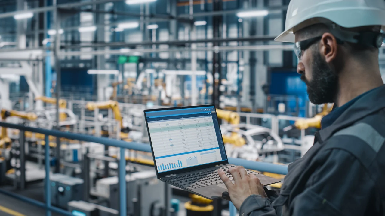 COFOMO – Specialized firm in digital transformation and artificial intelligence for the manufacturing industry – Man consulting a laptop to monitor factory performance.