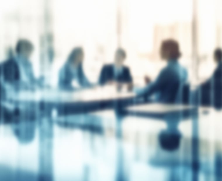 Group of people in a conference room discussing a roadmap to prioritize and optimize the use of artificial intelligence in their organization.