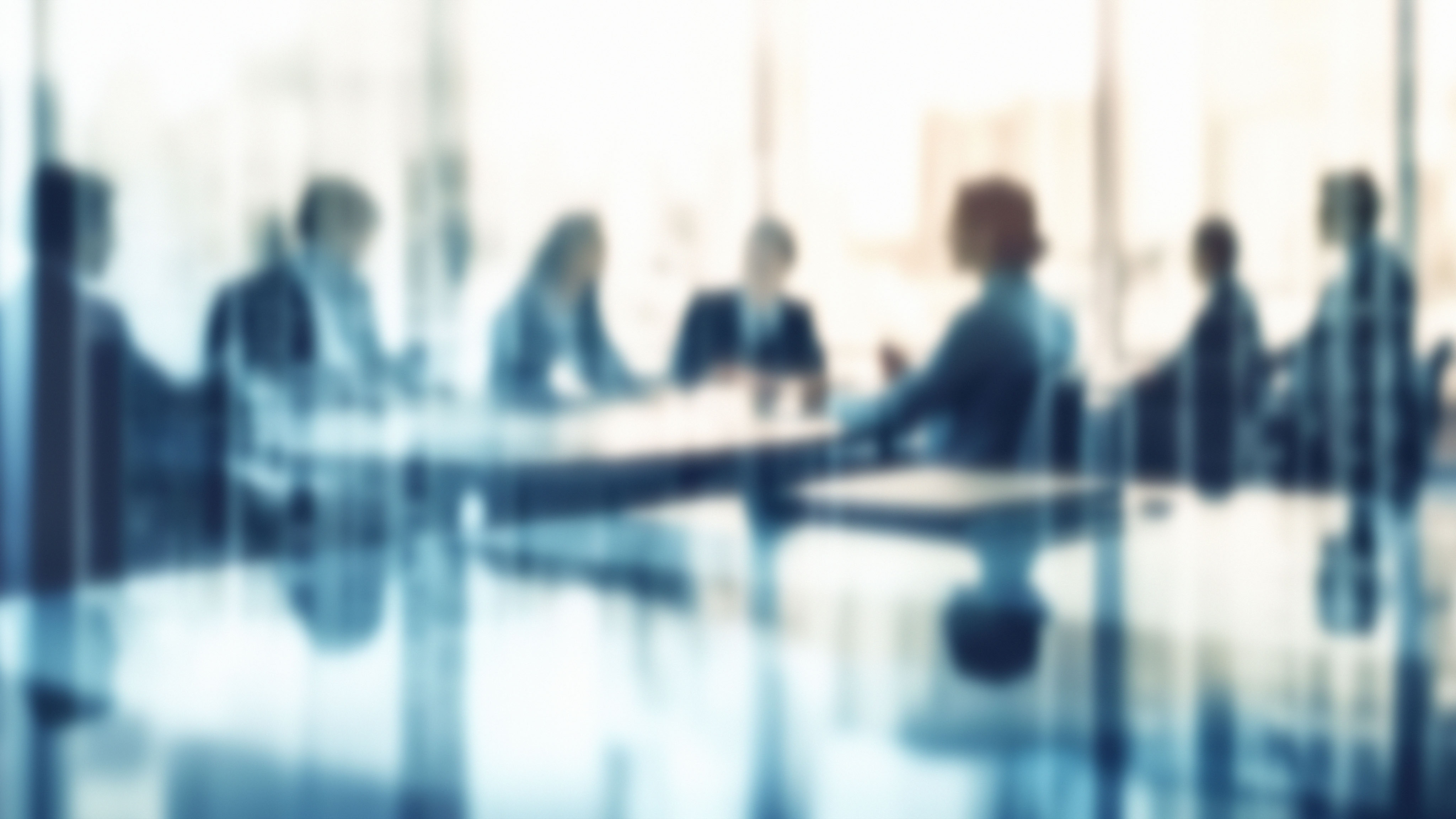 Group of people in a conference room discussing a roadmap to prioritize and optimize the use of artificial intelligence in their organization.