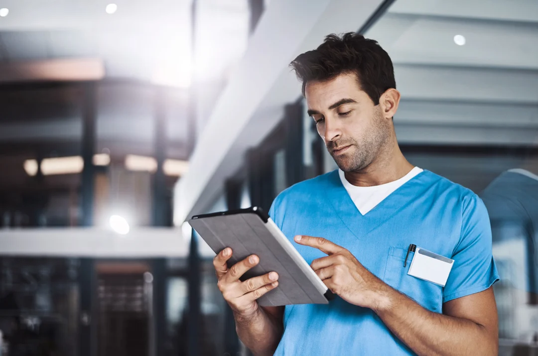 Médecin consultant un ipad où l'information est centralisée.