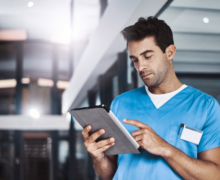 Médecin consultant un ipad où l'information est centralisée.