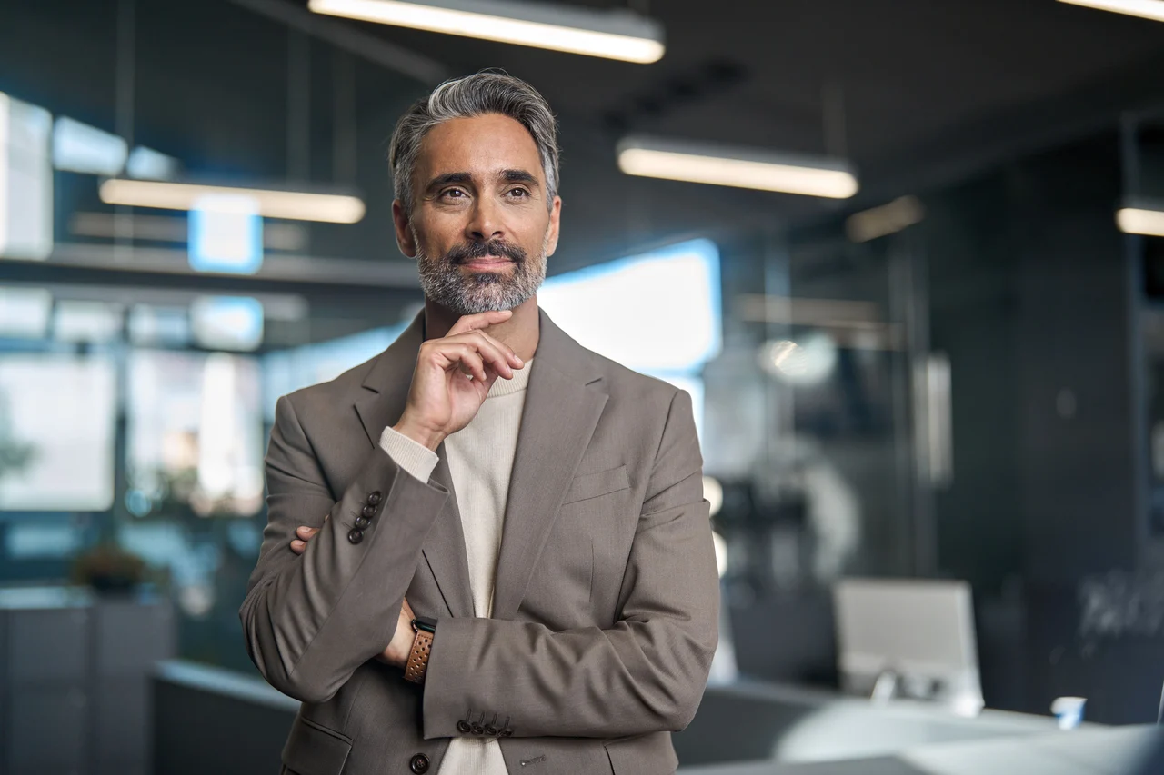 Expert COFOMO en transformation numérique et en intelligence artificielle regardant par la fenêtre de son bureau.