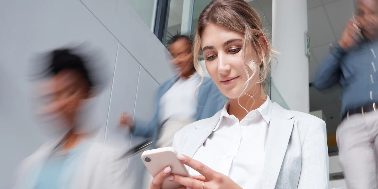 COFOMO expert in digital transformation and artificial intelligence descending stairs while looking at her smartphone.