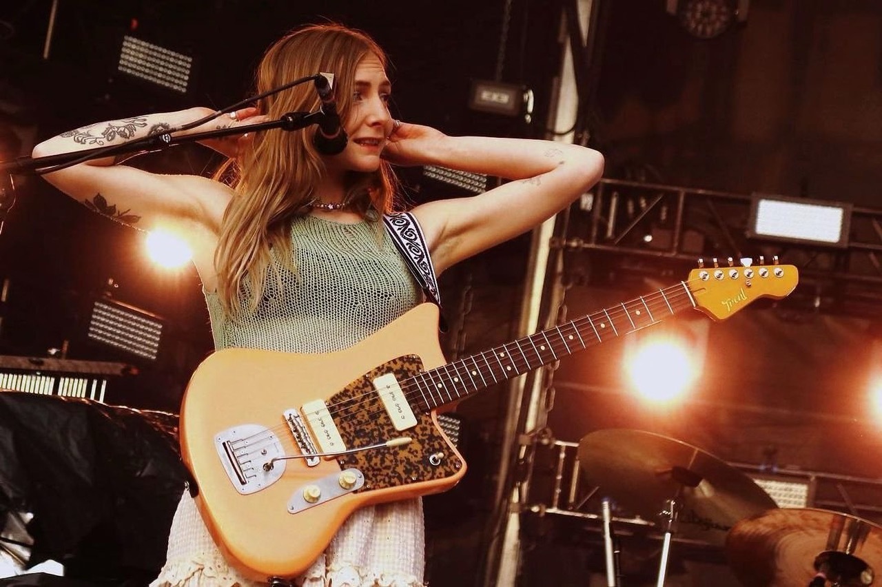 Hester from Wet Leg performing on-stage with her orange Model 1 guitar.