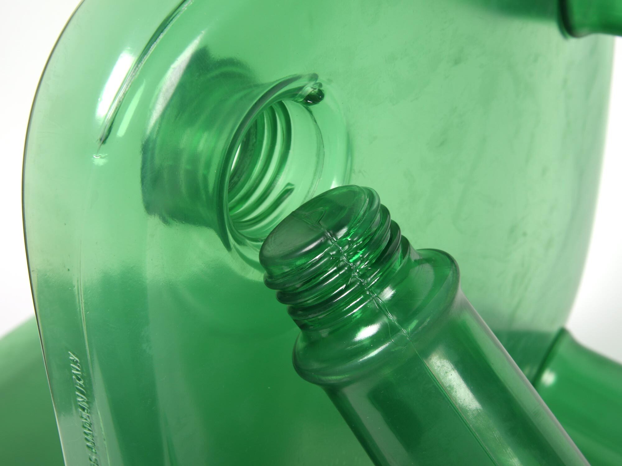 Green plastic bottles with threaded necks and screw-on caps, showing translucent material and cylindrical shapes in close-up view.