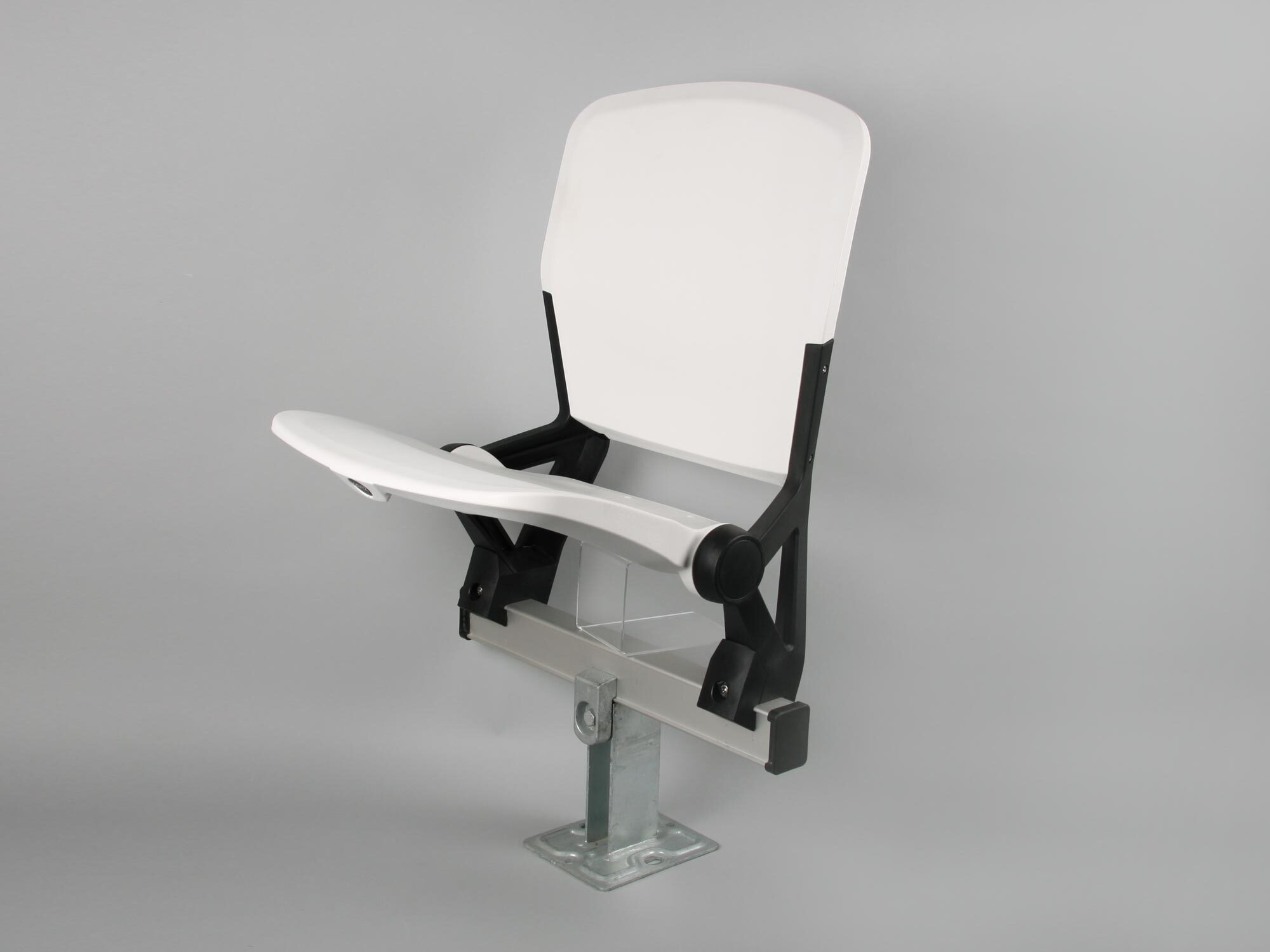 White auditorium seat with fold-down writing tablet, black metal frame, and silver pedestal base against grey background.