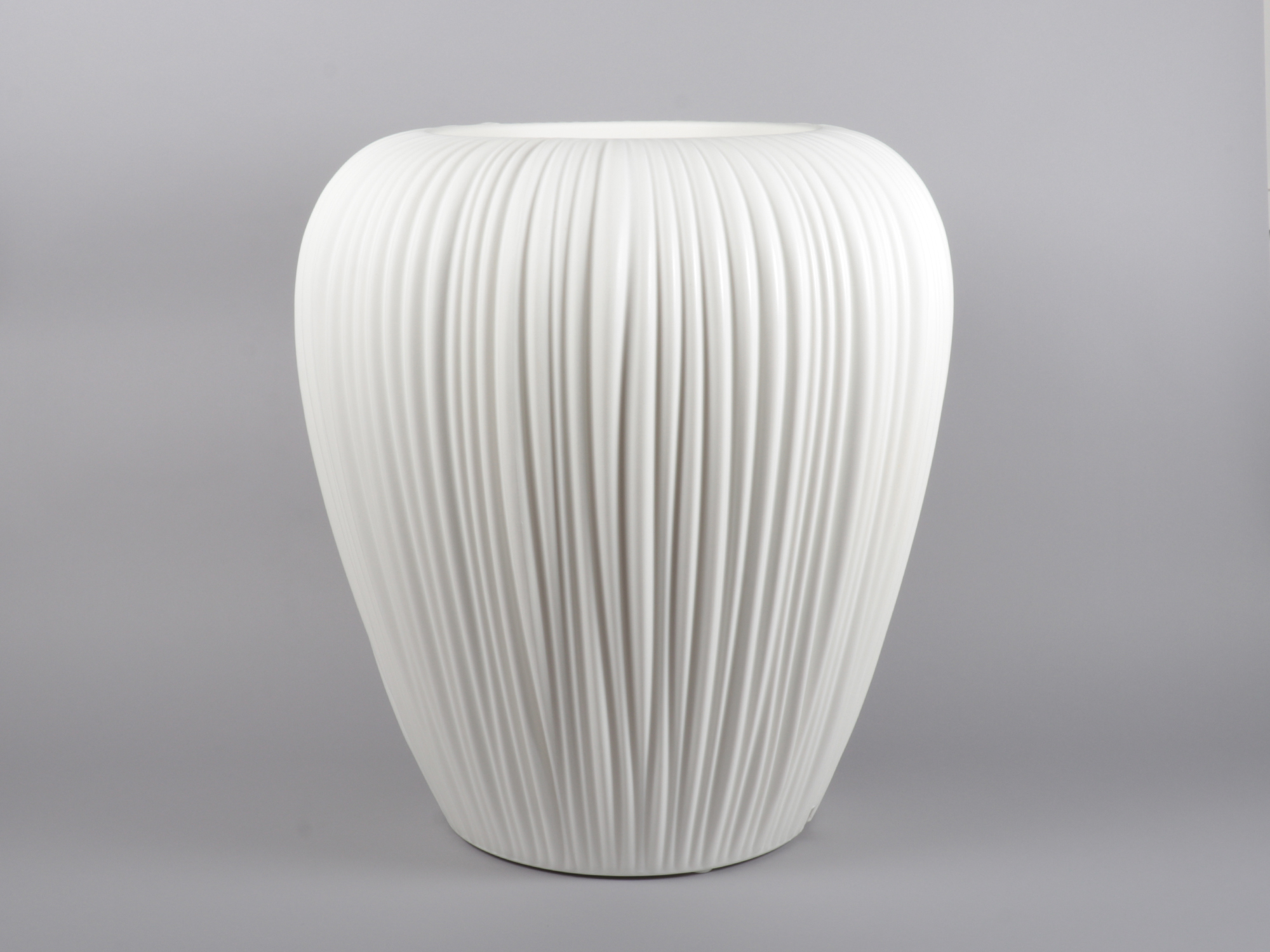 A white vase with a design consisting of several folds.