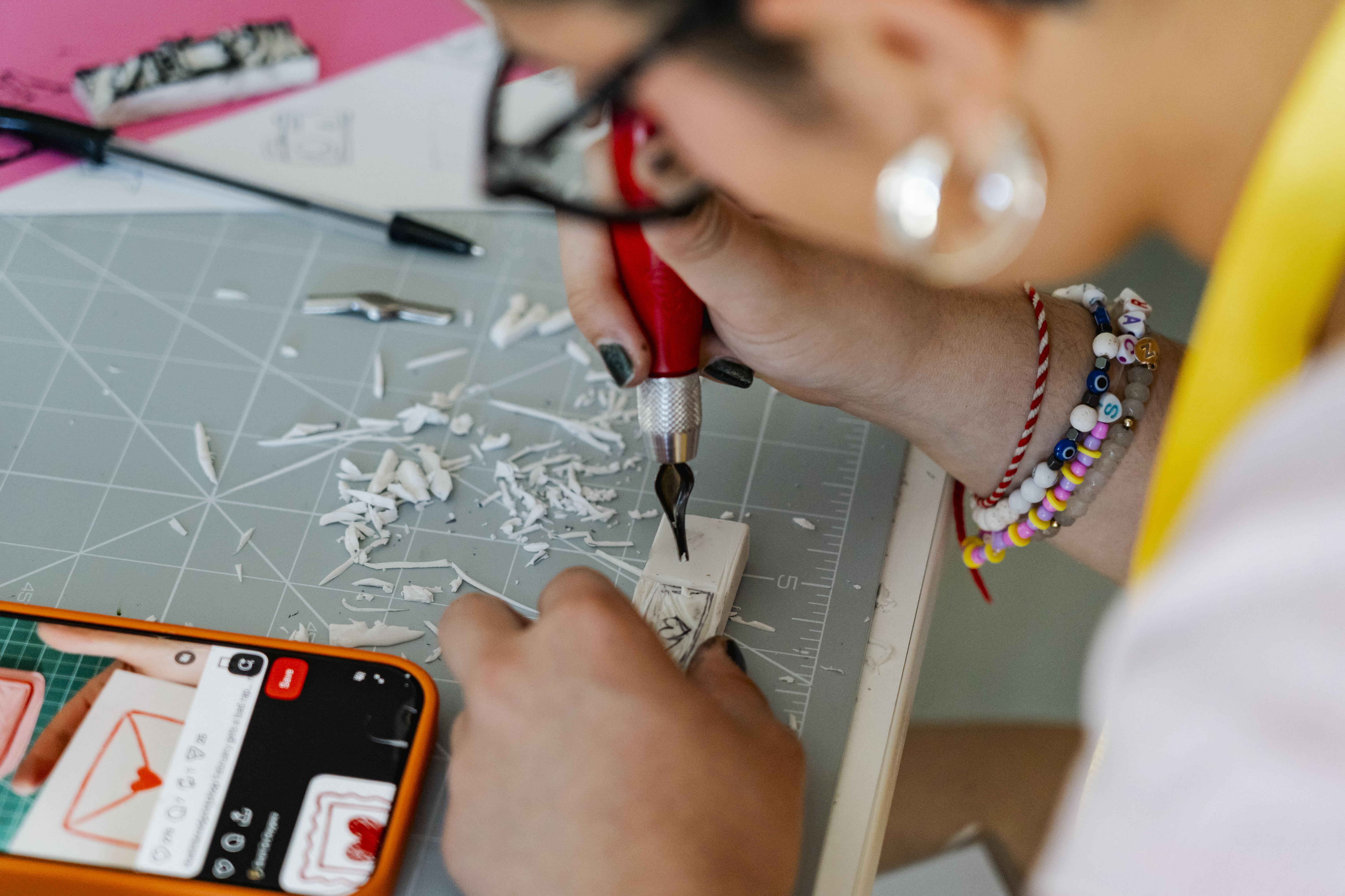student using a scalpel to carve their design into a rubber