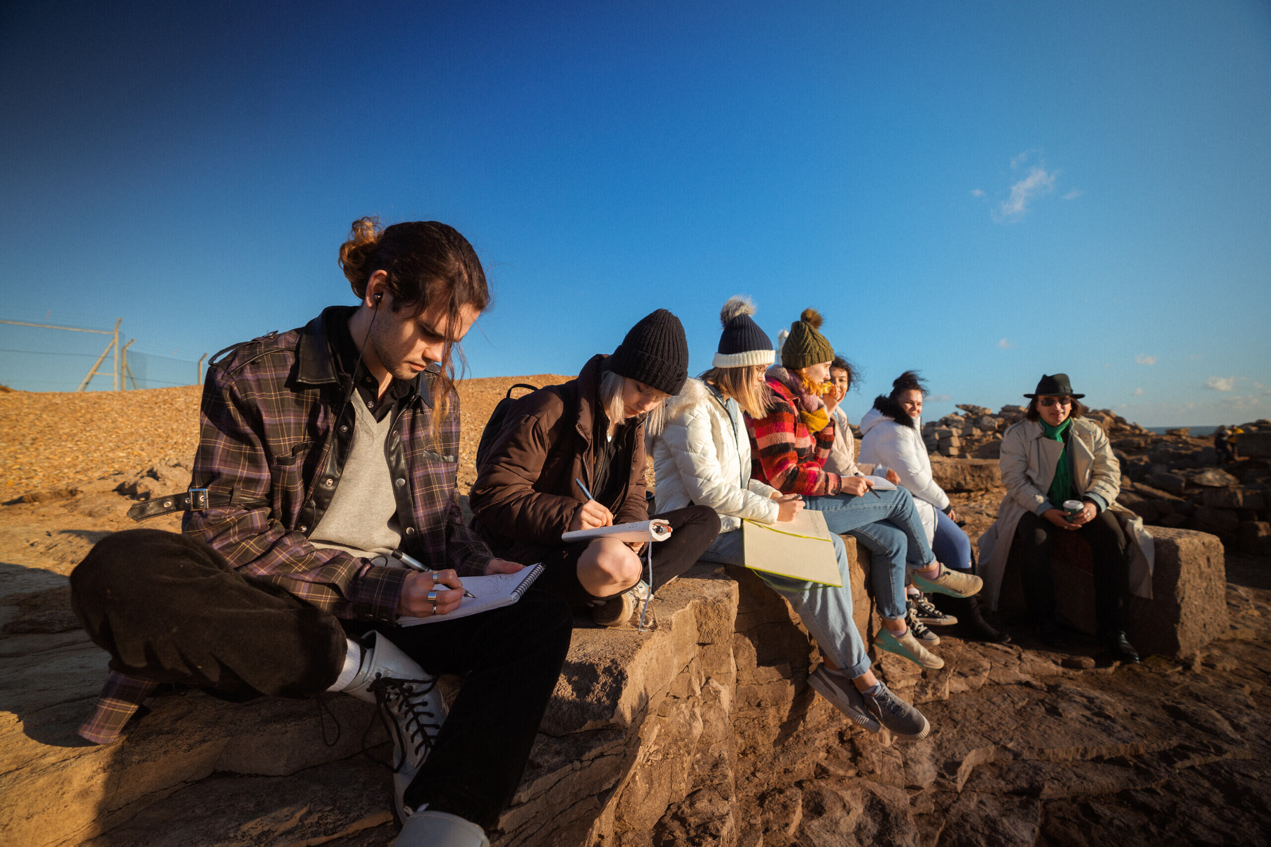 A group of creative writing students outside under a blue sky