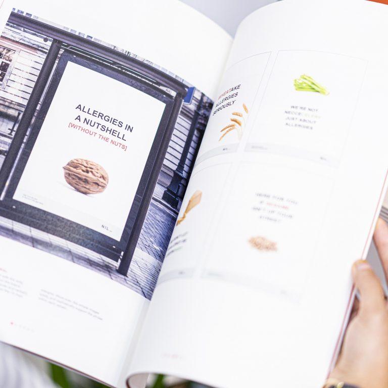 A double-page spread of a document. The left-hand page shows a poster with a walnut and the text 'Allergies in a Nutshell' above it.