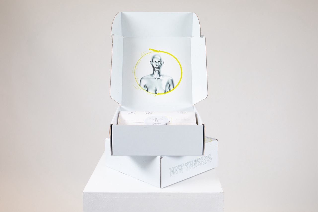 Mock-up box for New Threads packaging showing a metallic figure, white background.