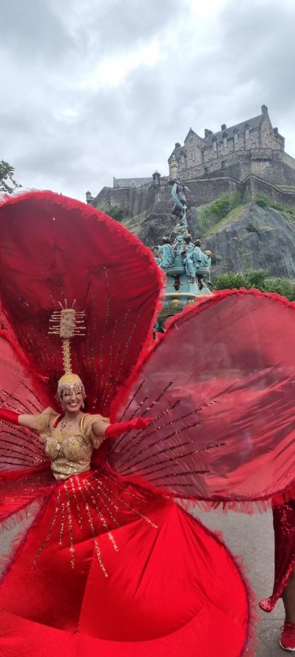 An extravagant big red carnival-style costume worn outdoors by Dora Voros.