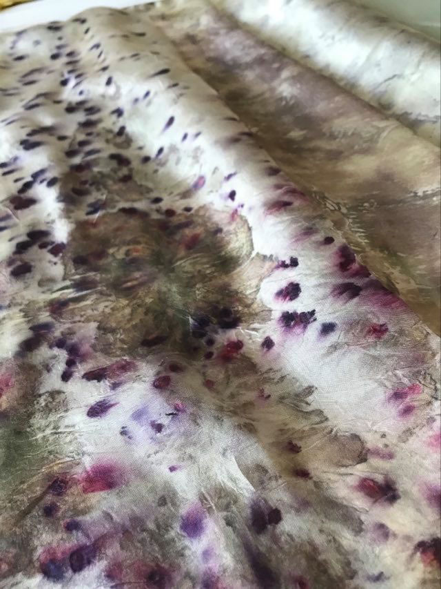 Close-up of a pleat of fabric with brown, white, pink and purple spotted pattern.