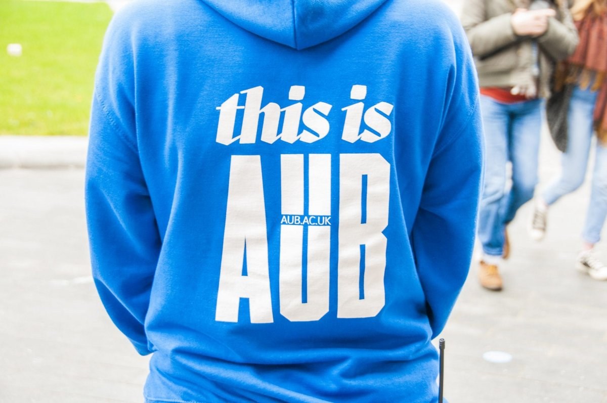 Student Ambassador wearing a blue hoodie which, on the back, reads 'this is AUB' on a Open Day