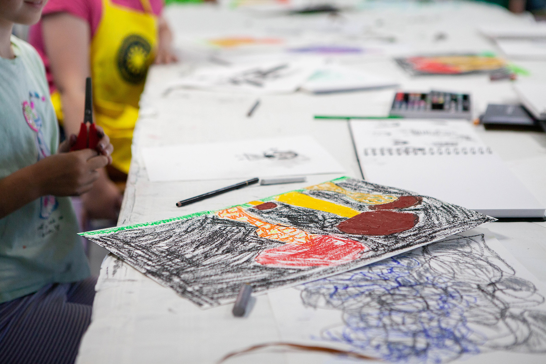 A close-up image of a piece of student work; an abstract series of shapes produced with coloured crayons