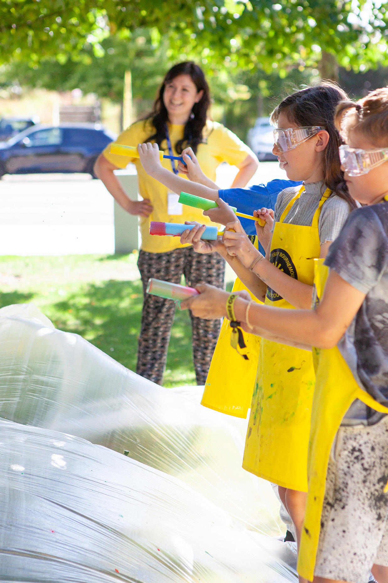 A group of young students are using paint guns