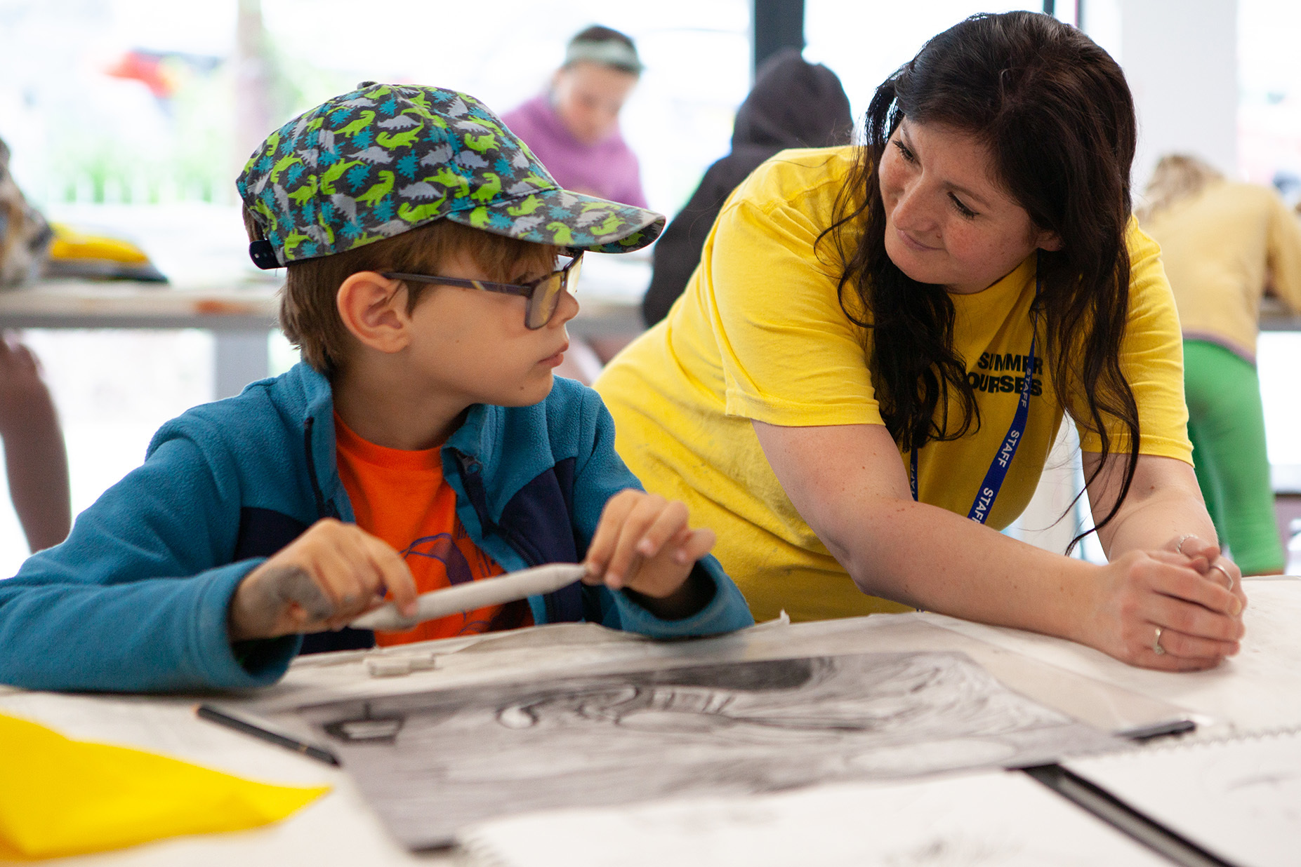 A young student is discussing their work with a teacher