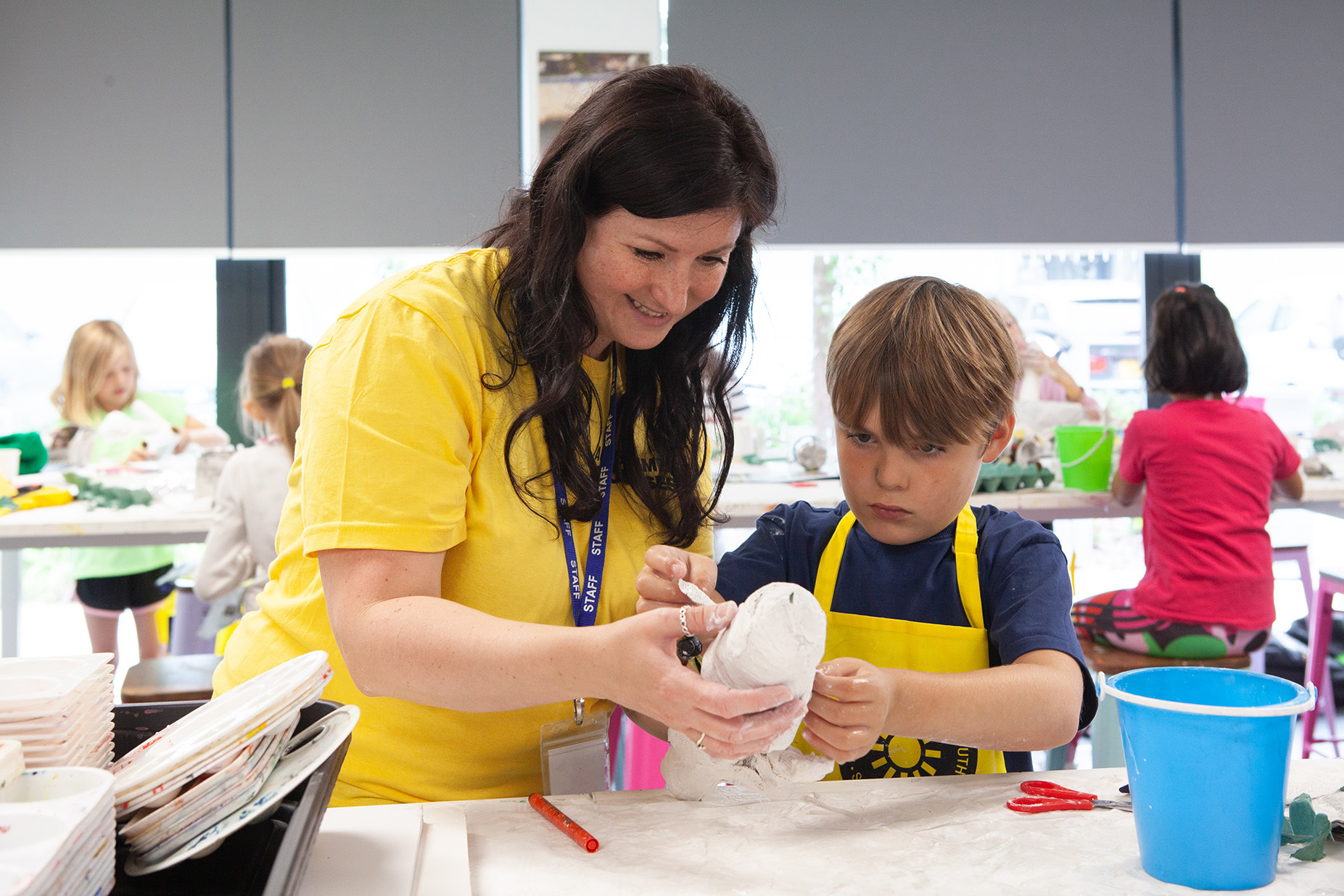 A young student is being helped by a teacher