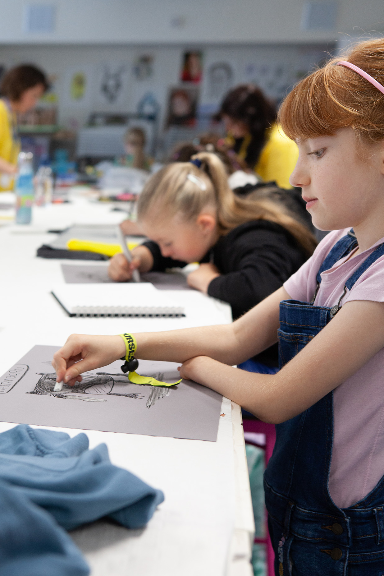A young student is drawing with charcoal