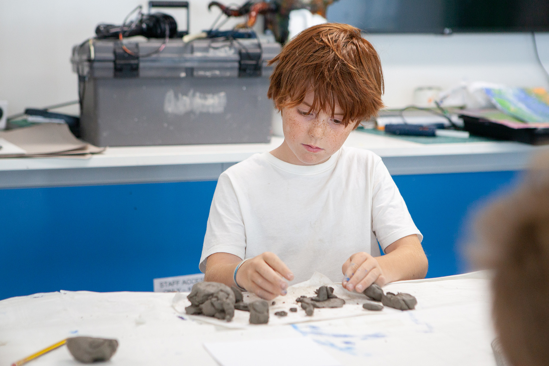 A young student making a clay sculpture