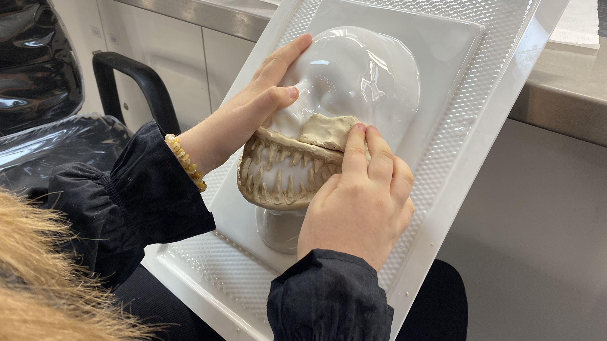 A student is moulding a prosthetic face piece