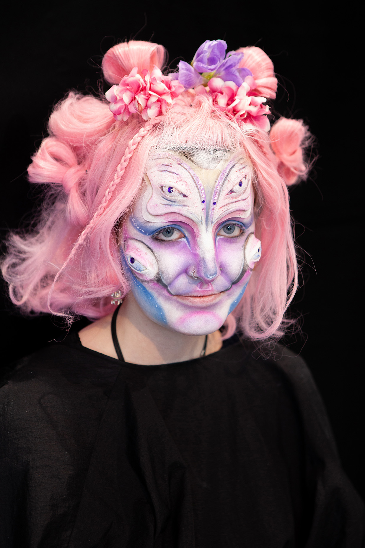 An example of character makeup: a student has flowers in their hair and colourful marks on their face