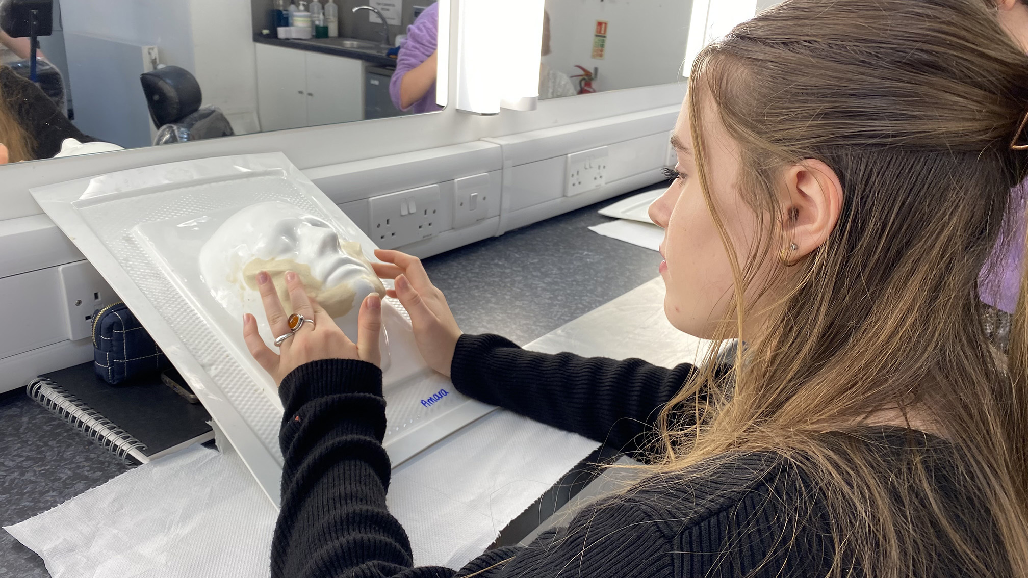 A student is moulding a prosthetic face piece