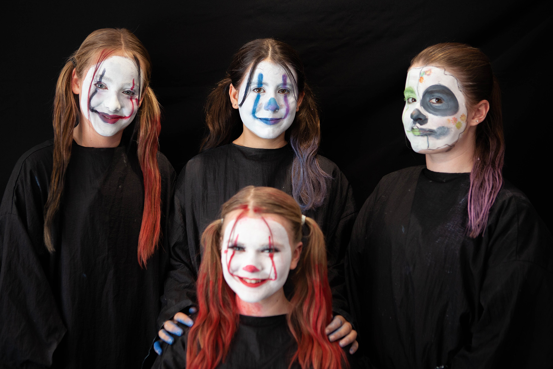 An example of character makeup: a group of students have their faces painted like clown