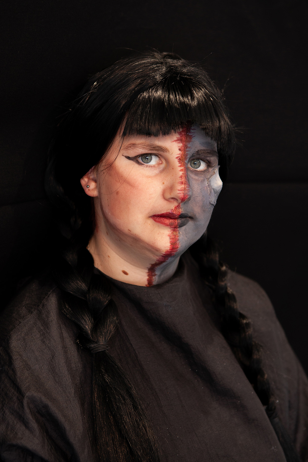 An example of character makeup: student has face half-painted with mechanical-style paint