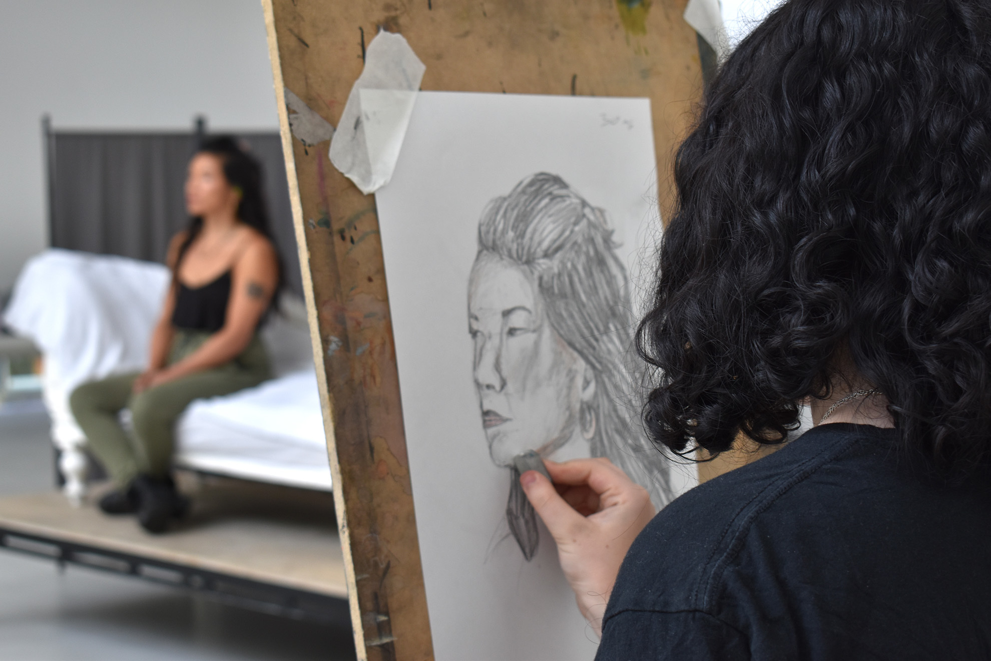 Students are drawing portraits on easels