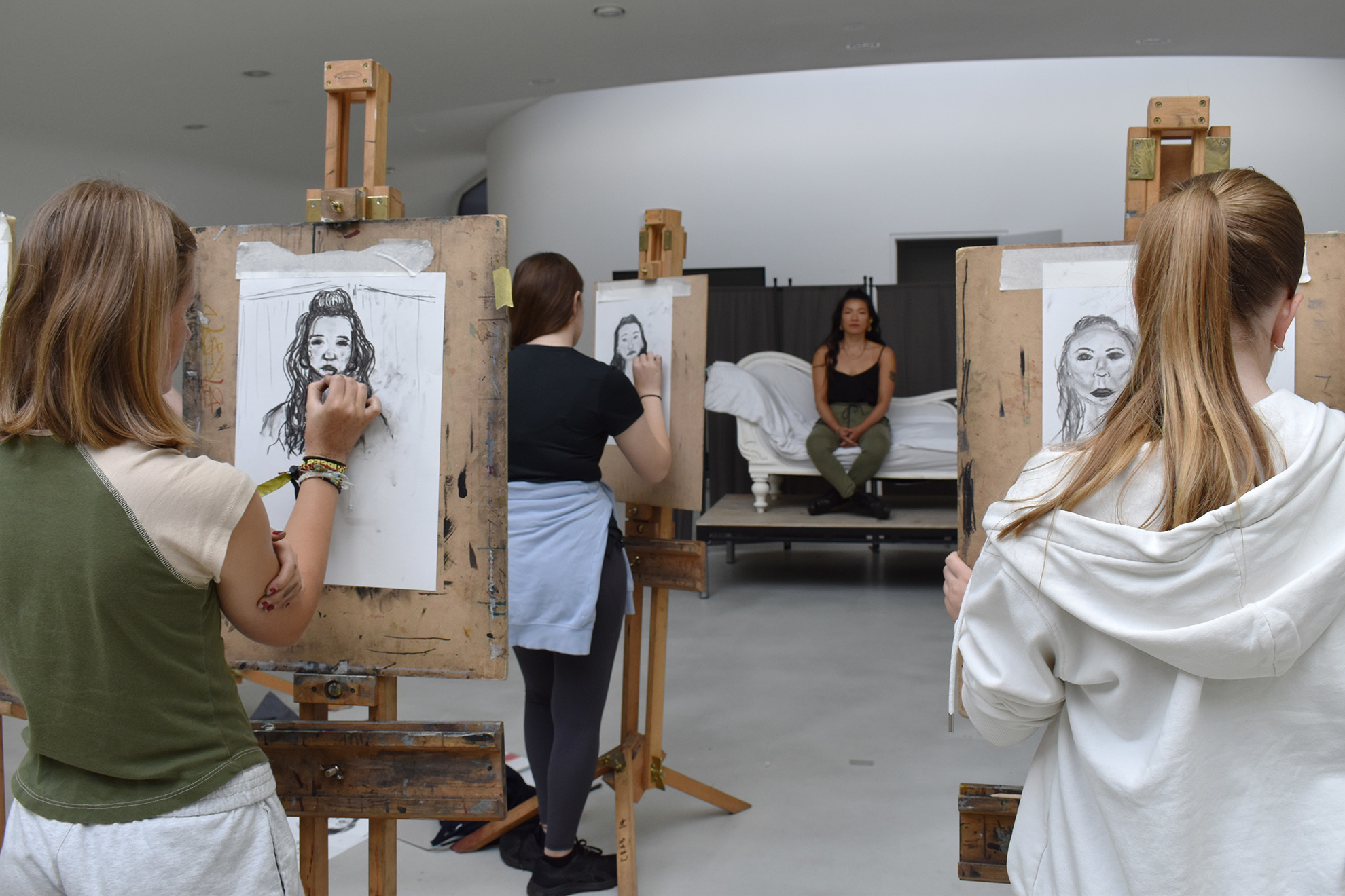 Students are drawing portraits on easels