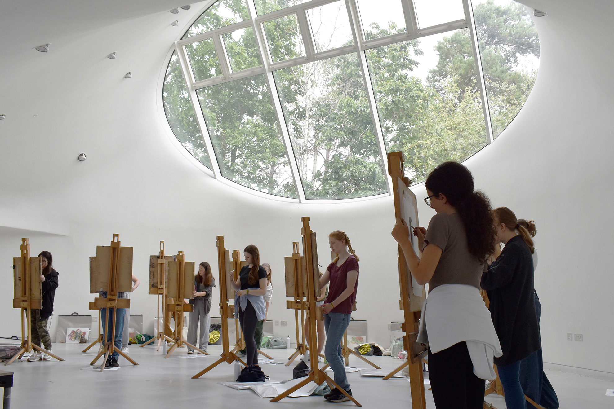 Students are drawing portraits on easels