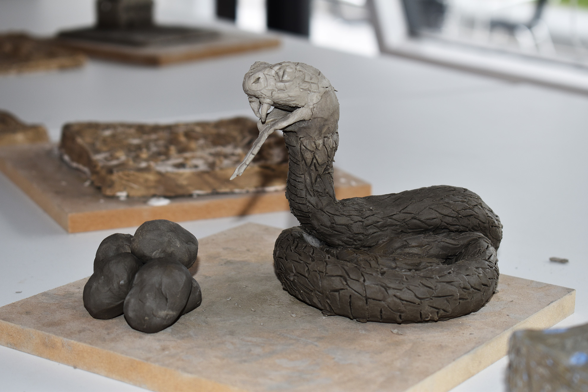 A sculpture of a snake made from clay