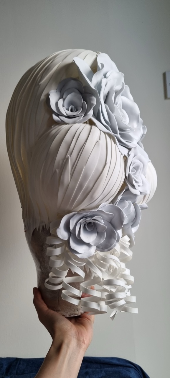 An eccentric-style white flowery wig by Dora Voros.