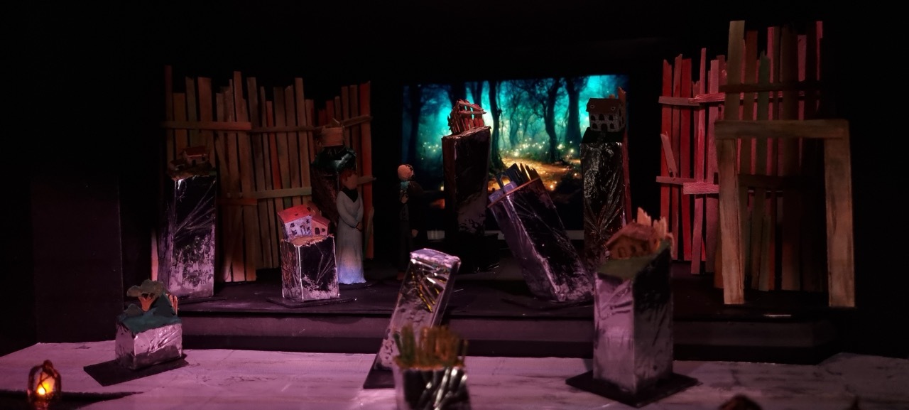 A model set design with wooden and silver-foil structures.