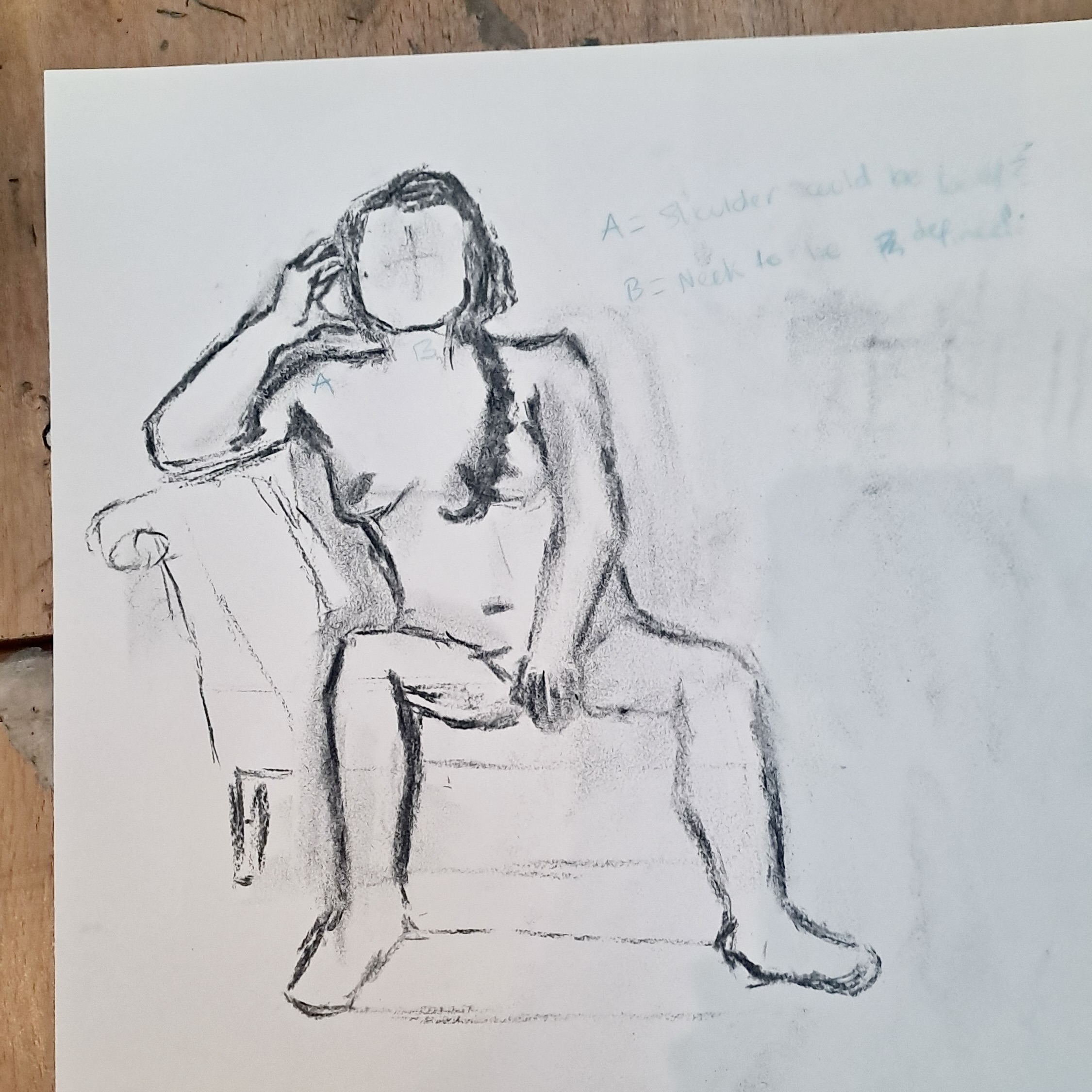 A charcoal sketch of a seated nude woman reclining on an armchair, with a faint handwritten note in the upper right corner.