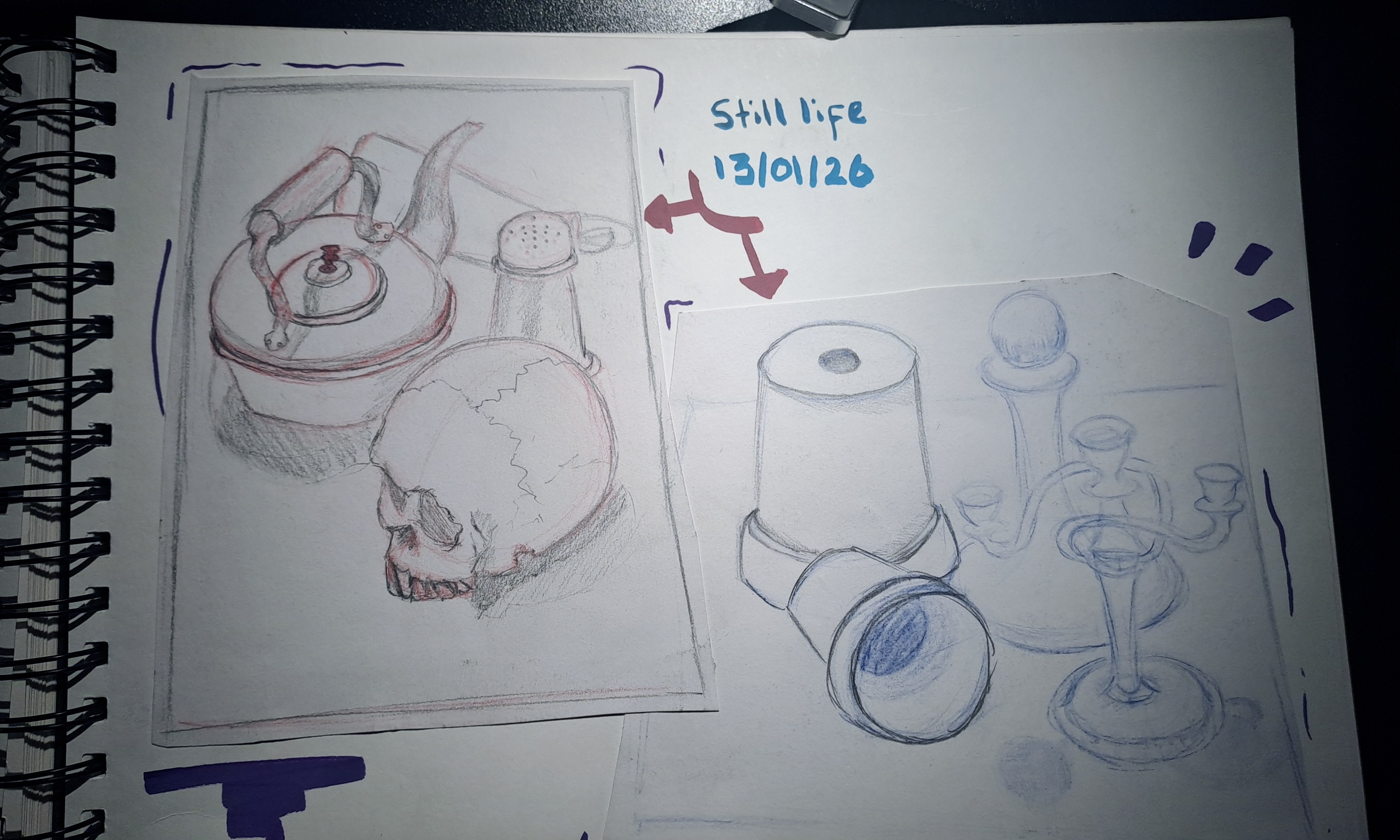 A sketchbook page showing two still life pencil drawings, including a skull with a teapot on the left and a cup, bottle and glassware on the right, with handwritten notes in blue ink.