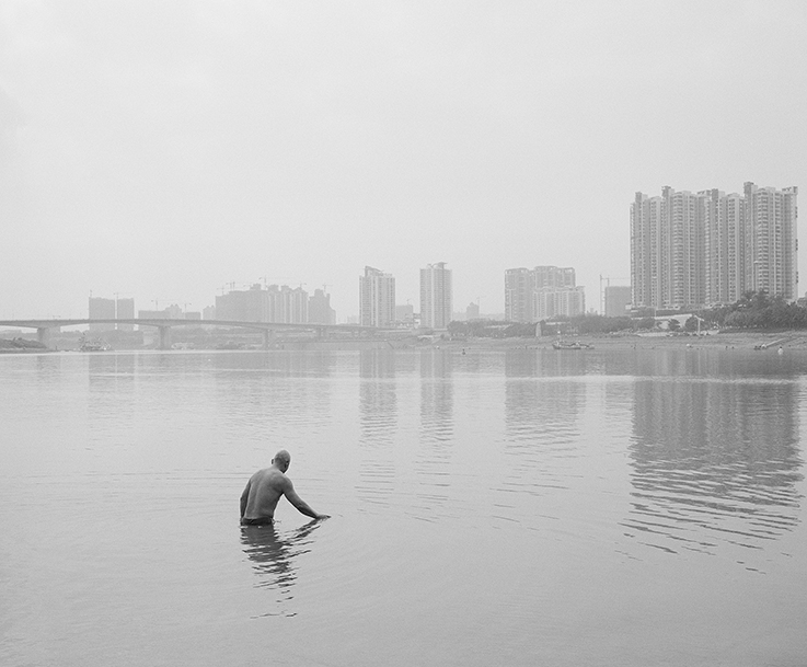 black and white photograph on man in river