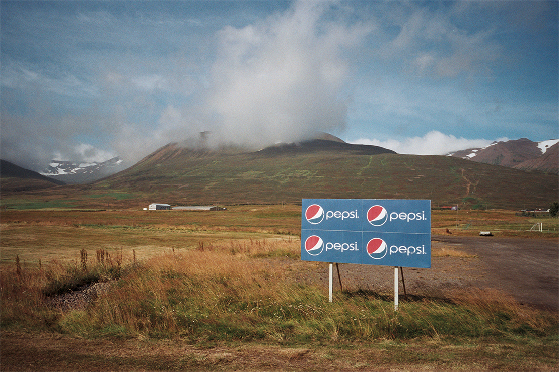 Photograph of Pepsi sign in front of a mountain range