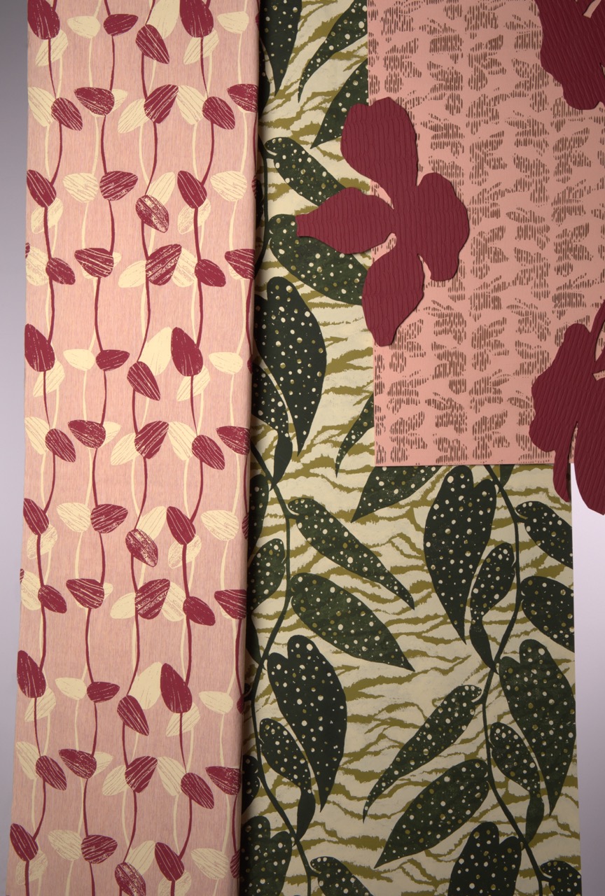 Three fabric patterns displayed side by side. The left pattern features small red leaves on a pale pink background, the centre showcases large maroon flowers on a textured pink surface, and the right has dark green leaves with white dots against a lighter green backdrop.