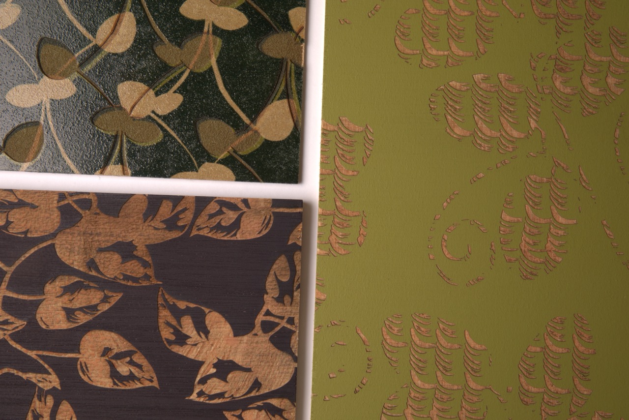 Three textured wall coverings displayed together. The top left features a dark green design with leaves and flowers, the bottom left shows a dark background with golden leaf patterns, and the right side has a light green surface with embossed leaf motifs.