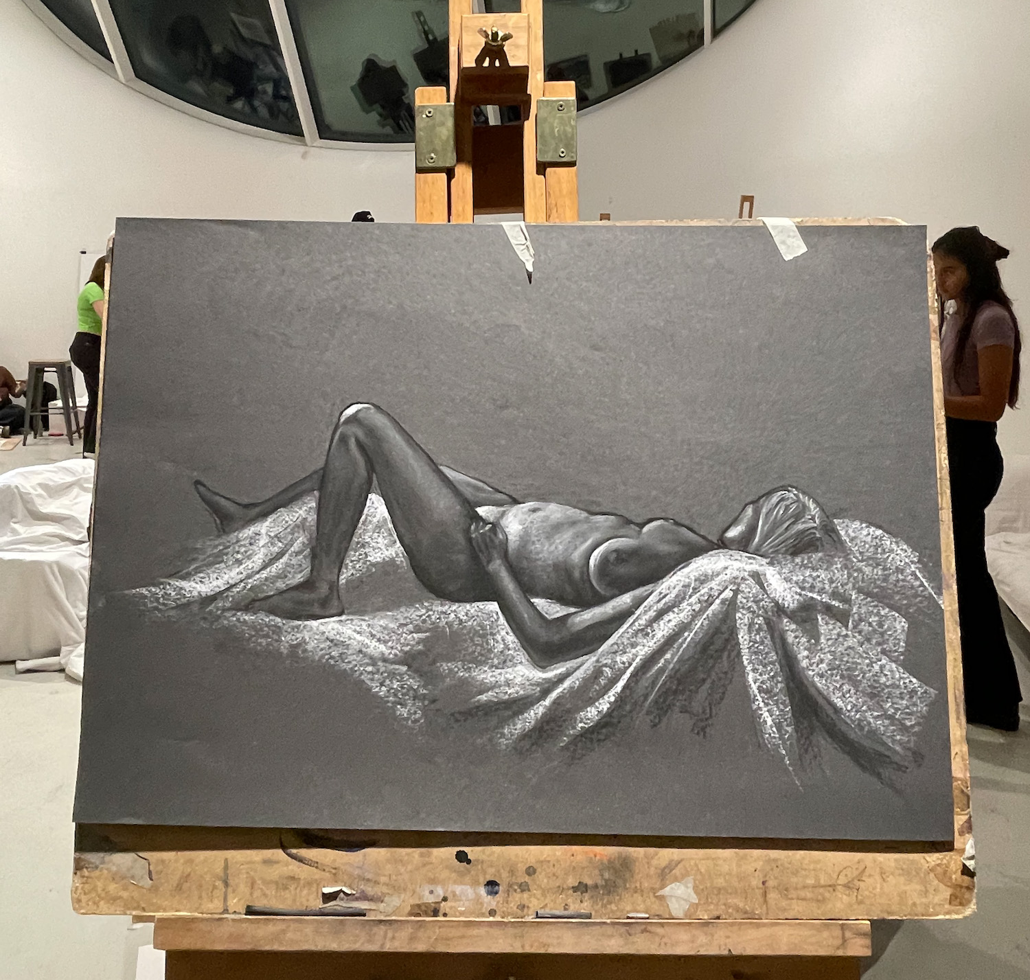 Canvas showing a life drawing in grey of a nude female lying back and facing away from the viewer.
