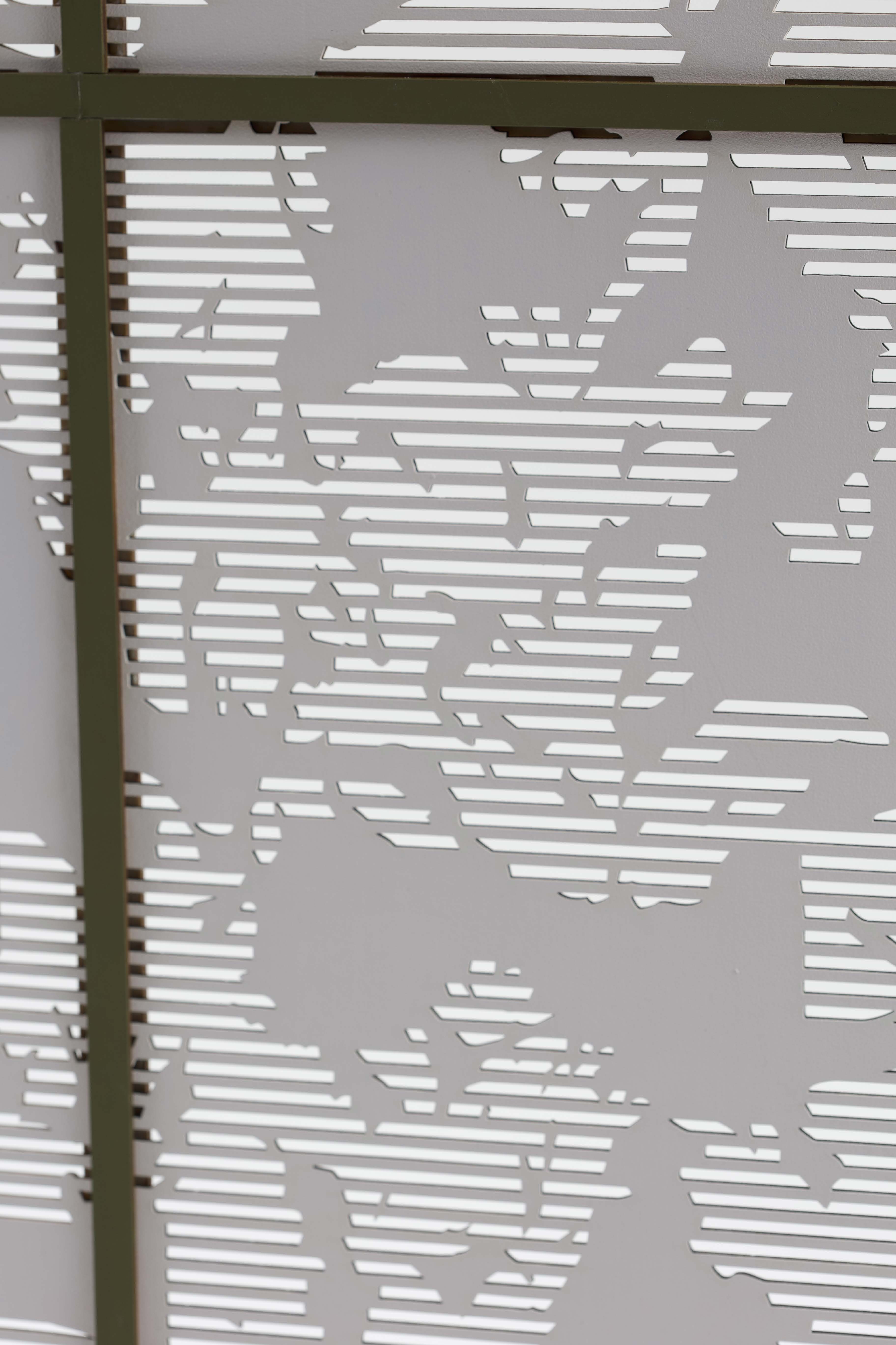 A close-up view of a decorative panel featuring cut-out floral patterns against a white background. The panel has alternating solid and open lines, creating a layered effect with a modern design.