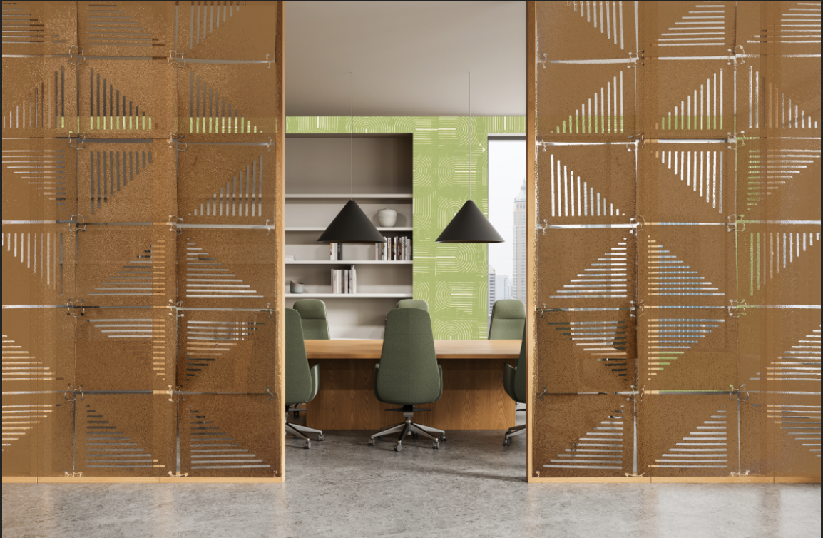Two semi-transparent wooden partitions with geometric patterns separate a meeting room from an open area. Inside, a large wooden table is surrounded by green chairs, and a shelf with books and decorative items is visible against a green wall.