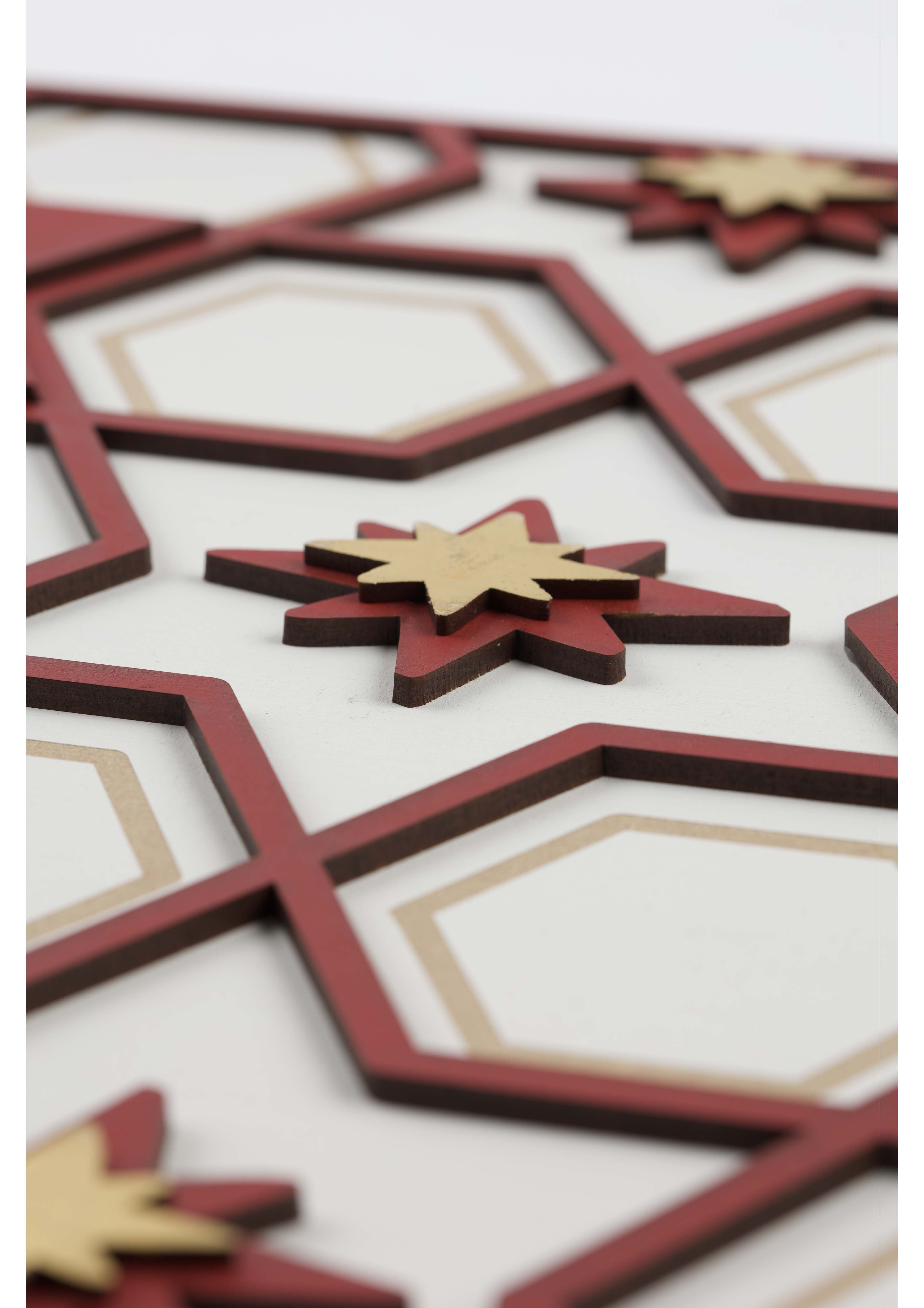 A patterned surface featuring interlocking hexagons in cream, red, and gold colours. Red and gold star shapes are layered on top of the hexagons, creating a decorative design.