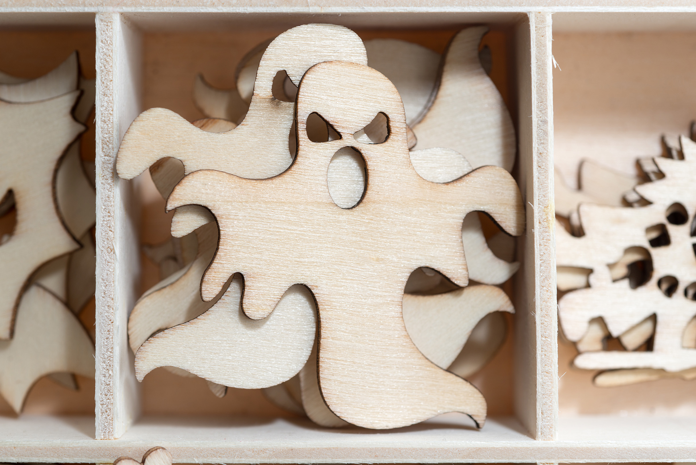 Wooden cut outs of a cartoon ghost.