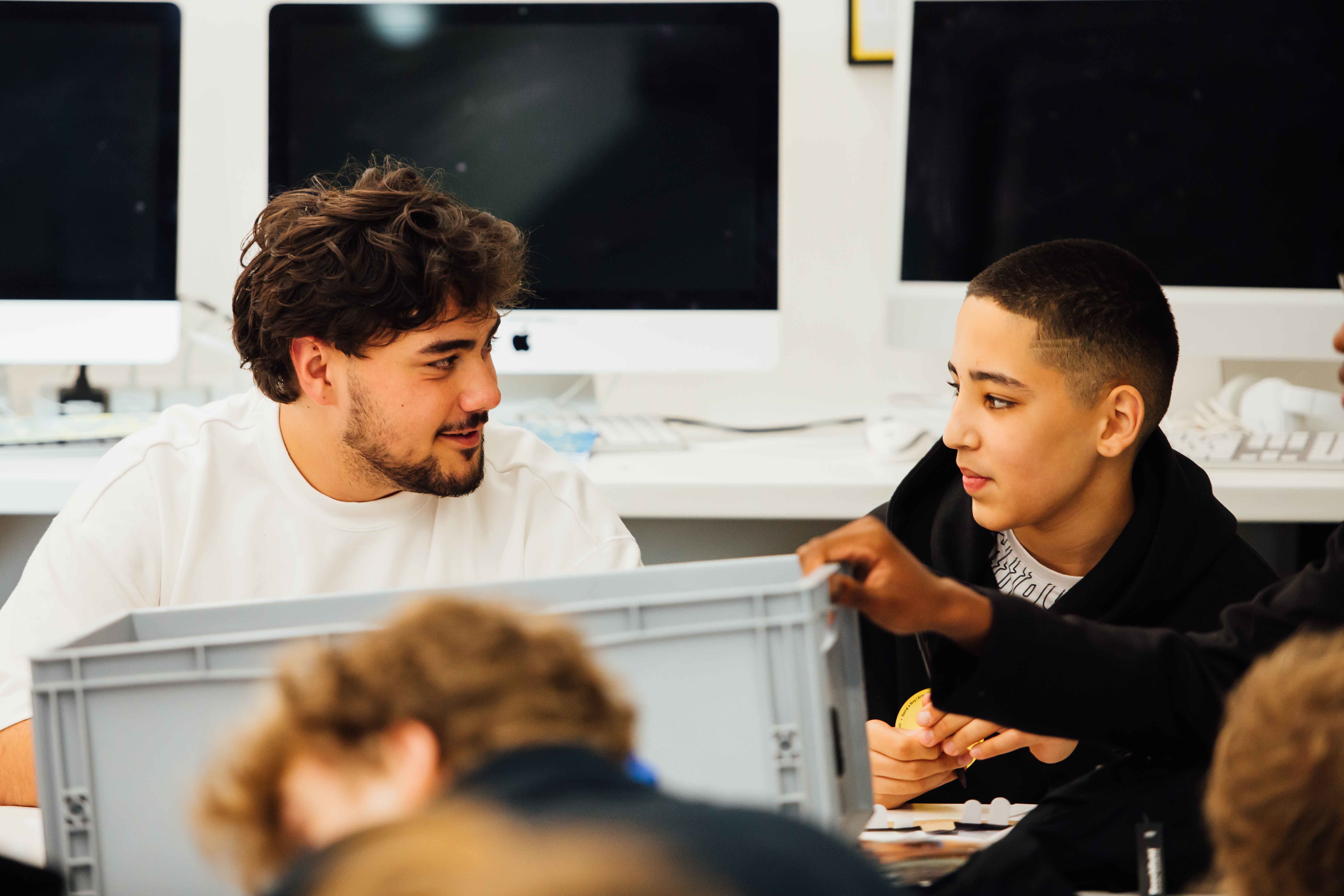 Two boys sat in a studio in conversation.