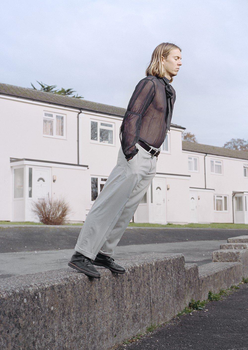 Man leaning on the edge of a wall