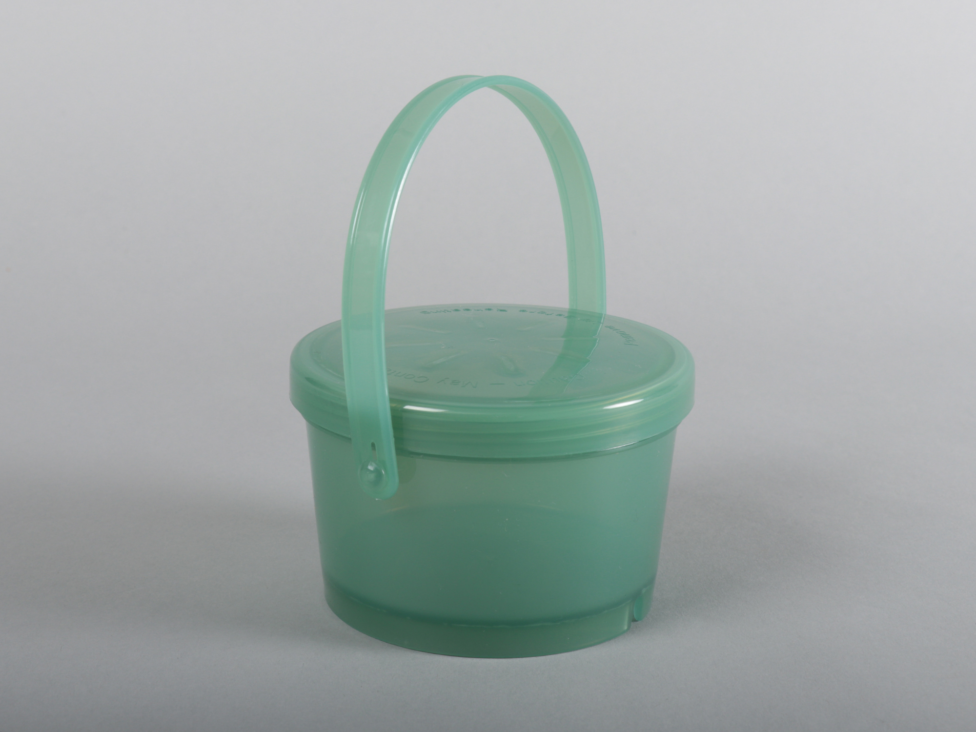 A small plastic pot with a handle pointing up.